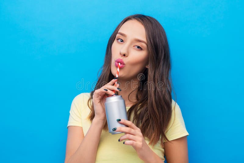 Soda bebendo da jovem mulher ou do adolescente da lata
