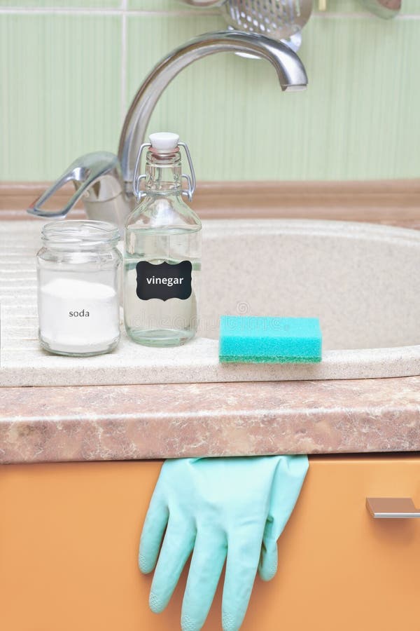 soda and vinegar on a sink with rubber glove and dish cleaning sponge. alternative eco cleaning product. affordable and