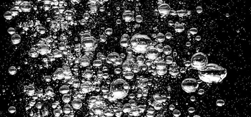 Soda water bubbles splashing underwater against black background royalty free stock image