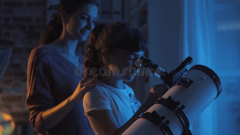 Soeurs mignonnes observant les ?toiles avec un t?lescope photographie stock Soeurs mignonnes observant les ?toiles avec un t?lescope photographie stock