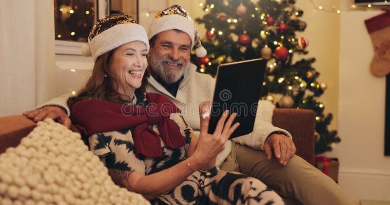 Sofa lycklig och ett par med en tablett på julklappar för onlinekällor och köp gåva tillsammans. kvinnor och män royaltyfri bild