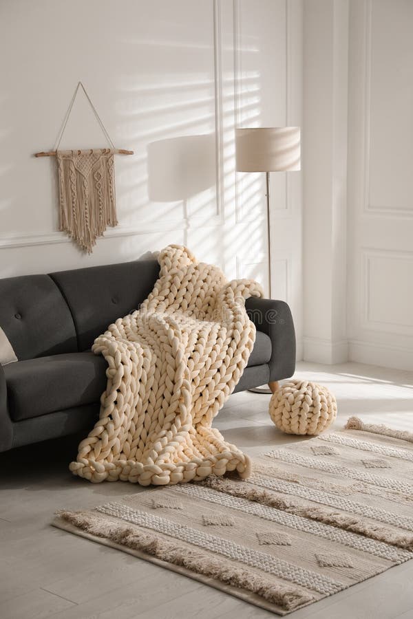 Soft Chunky Knit Blanket on Sofa in Living Room. Interior Design Stock