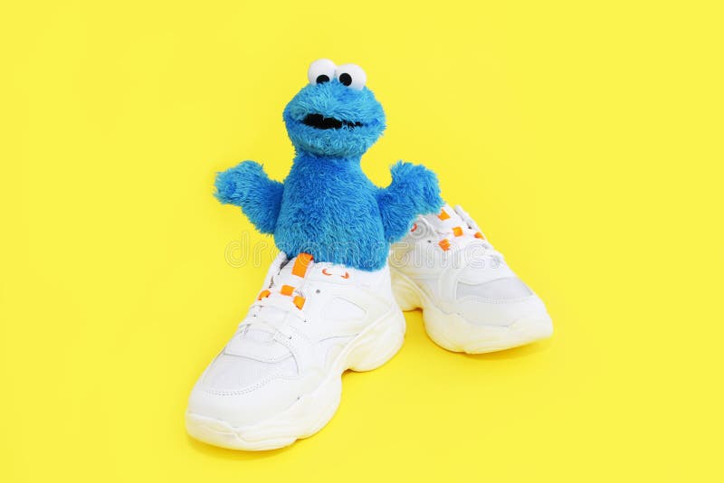 Soft Fluffy Children`s Toy Cookie Monster in White Shoes Sneakers on a