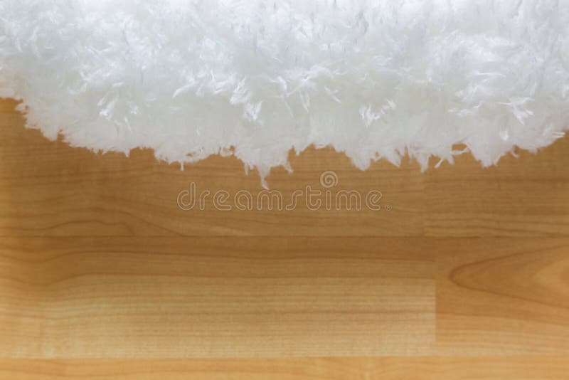 Closeup texture of soft fluffy white cloud like fur microfiber fabric on blurred wooden background. Closeup texture of soft fluffy white cloud like fur microfiber fabric on blurred wooden background