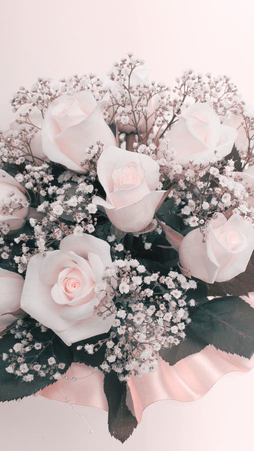 Soft focus gypsophila and rose flower bouquet. Wedding vertical beige pink background