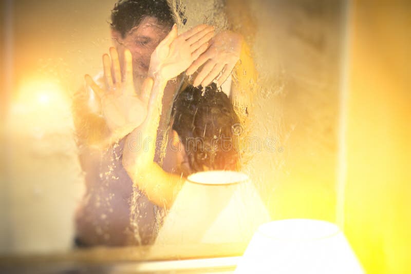 soft focus. naked man and woman take shower together in bathroom with a win...
