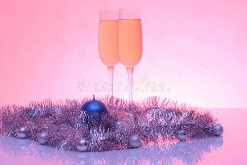 Soft tinted photo of christmas and New Year decoration and two glasses of champagne with reflection