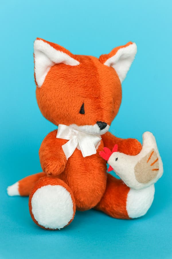 Soft Toy Ginger Fox with Chicken on a Blue Background Stock Photo