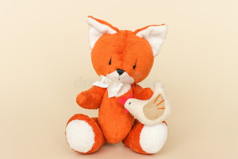 Soft Toy Ginger Fox with Chicken on a Yellow Background Stock Photo
