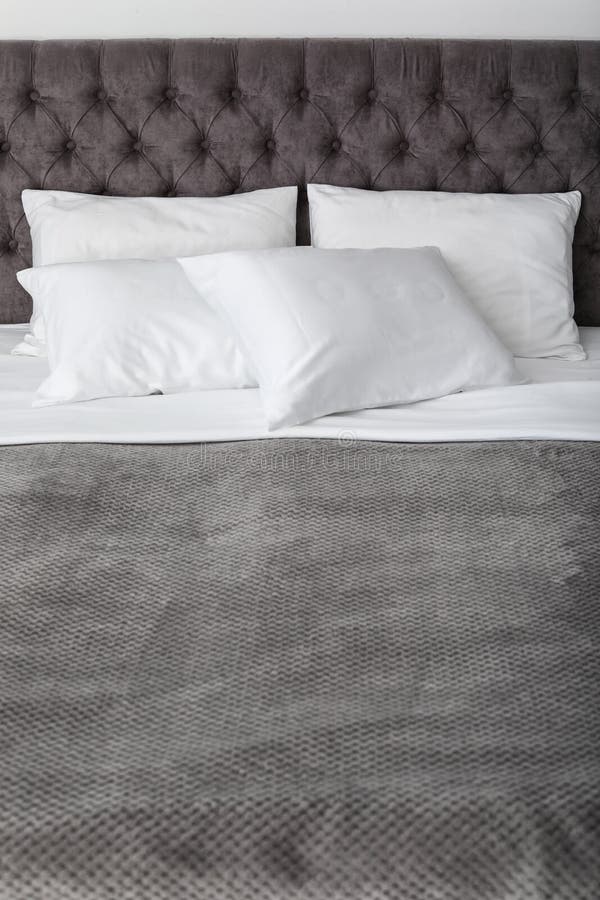 Soft white pillows on comfortable bed