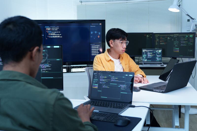 Software developers coding in a collaborative technology workspace programmers and software engineers developing code on multiple стоковое фото