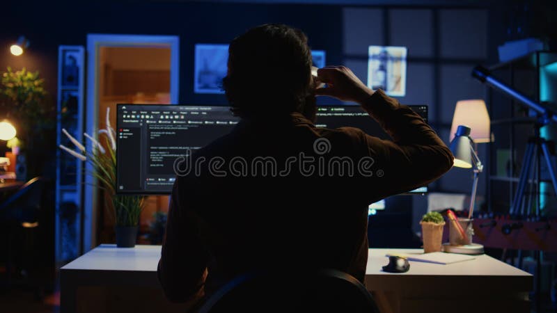 Software engineer writes complex binary code scripts on computer, close up. Teleworking IT specialist in home office using programming to safeguard consumer data, handheld camera shot, camera B. Developer coding program video