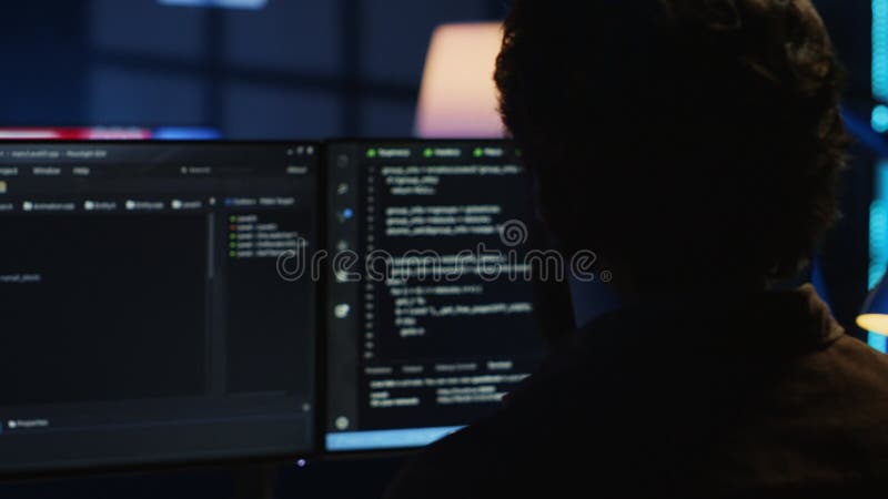 Software engineer writes complex binary code scripts on computer, close up. Teleworking IT specialist in home office using programming to safeguard consumer data, handheld camera shot, camera A. Developer coding program video