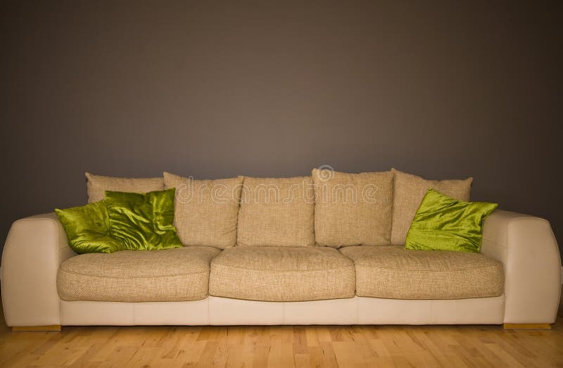 Large modern comfortable sofa in a neutral room with acid green scatter cushions. Large modern comfortable sofa in a neutral room with acid green scatter cushions