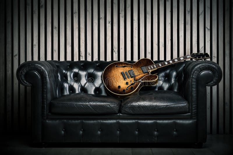 Sofá vacío del vintage y guitarra eléctrica con el fondo de madera moderno del estudio de grabación de la pared Concepto de la mú