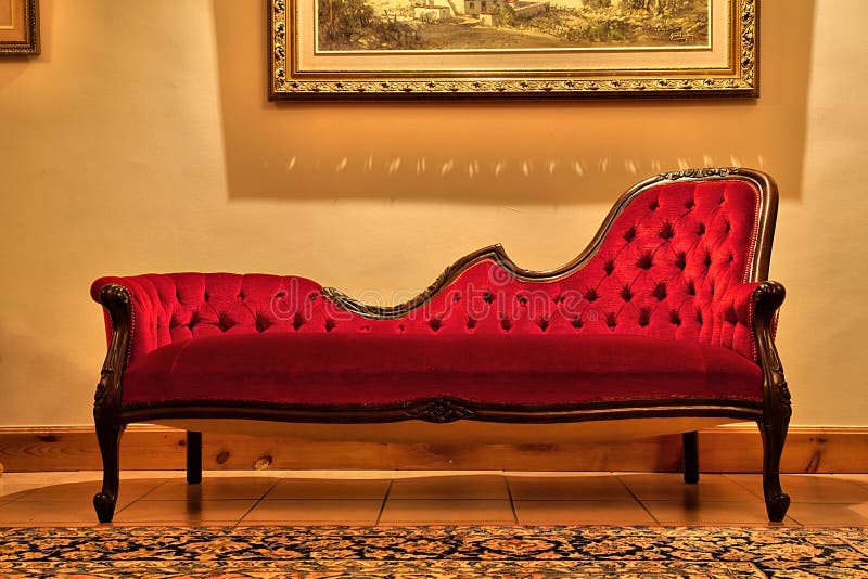 Sofá vermelho caro sob a pintura
