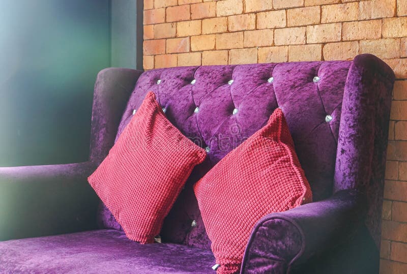 Sofá violeta de veludo luxuoso com o coxim vermelho para o assento imagem de stock Sofá violeta de veludo luxuoso com o coxim vermelho para o assento imagem de stock