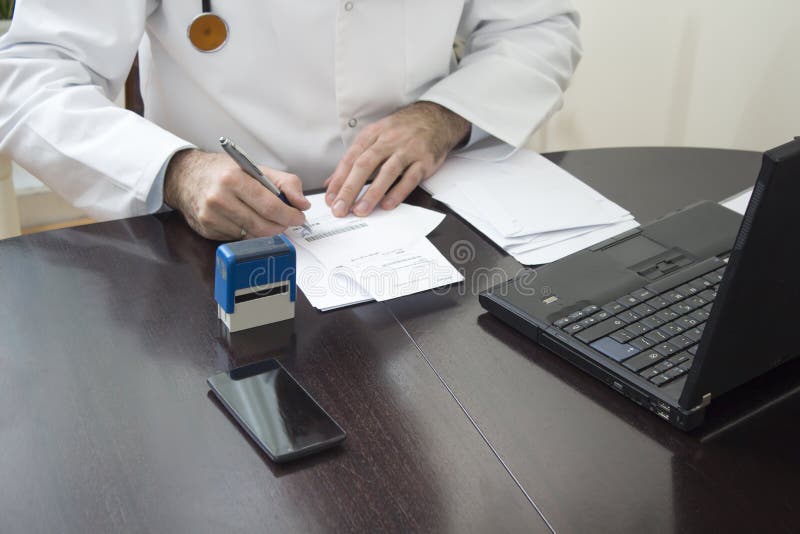 Soignez la main du ` s emboutie sur la prescription Le docteur écrit une prescription à son bureau images stock Soignez la main du ` s emboutie sur la prescription Le docteur écrit une prescription à son bureau images stock