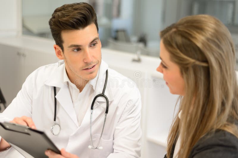 Soignez écouter le patient l'expliquant douloureuse dans son bureau image libre de droits Soignez écouter le patient l'expliquant douloureuse dans son bureau image libre de droits