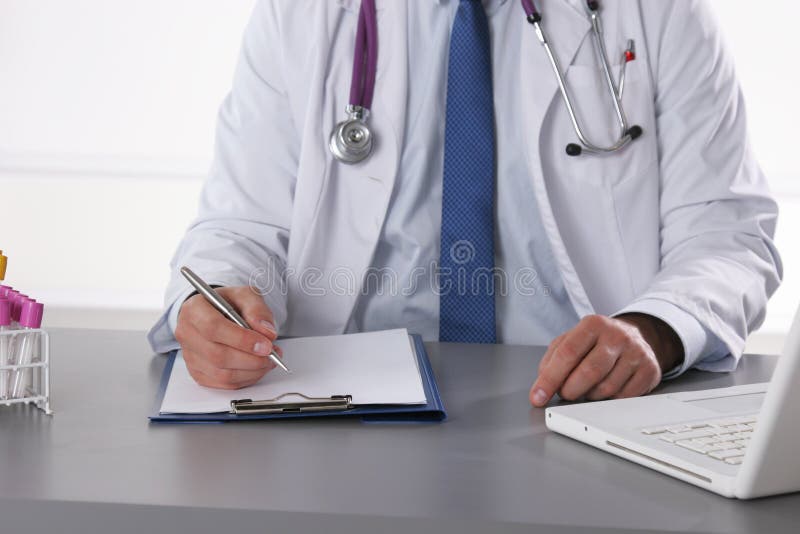 Soignez écrire une prescription se reposant sur son bureau image libre de droits Soignez écrire une prescription se reposant sur son bureau image libre de droits