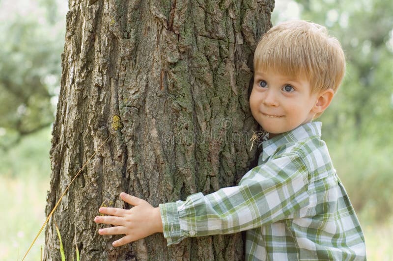 Soin de nature - étreinte de petit garçon un arbre image libre de droits Soin de nature - étreinte de petit garçon un arbre image libre de droits