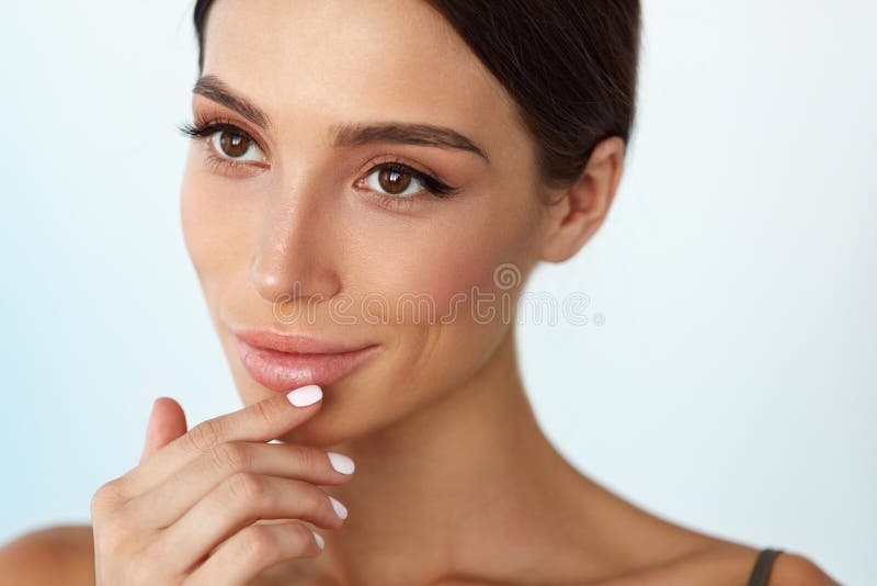 Soins de la peau de lèvres Femme avec le visage de beauté appliquant le baume à lèvres dessus images stock Soins de la peau de lèvres Femme avec le visage de beauté appliquant le baume à lèvres dessus images stock