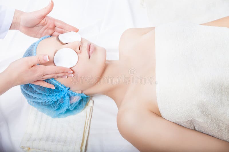 Soins de la peau - visage de nettoyage de femme par l'esthéticien image libre de droits Soins de la peau - visage de nettoyage de femme par l'esthéticien image libre de droits
