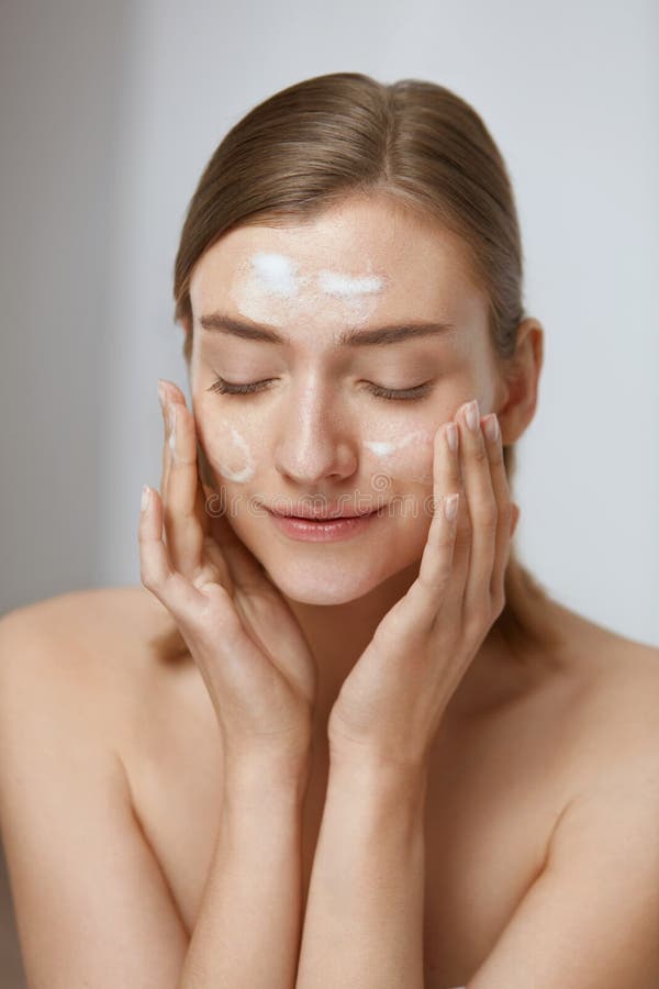 Belle Femme Nettoyant Son Visage Avec Un Traitement De Mousse Image stock -  Image du fille, fond: 37121499