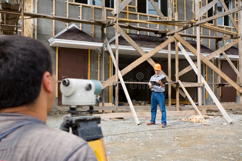 Building site.The builder looks in a level. Building site.The builder looks in a level.