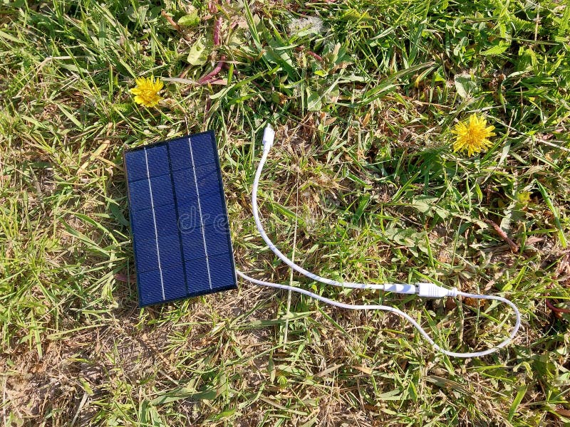 Solar Panel for Charging a Smartphone on the Grass Stock Photo Image
