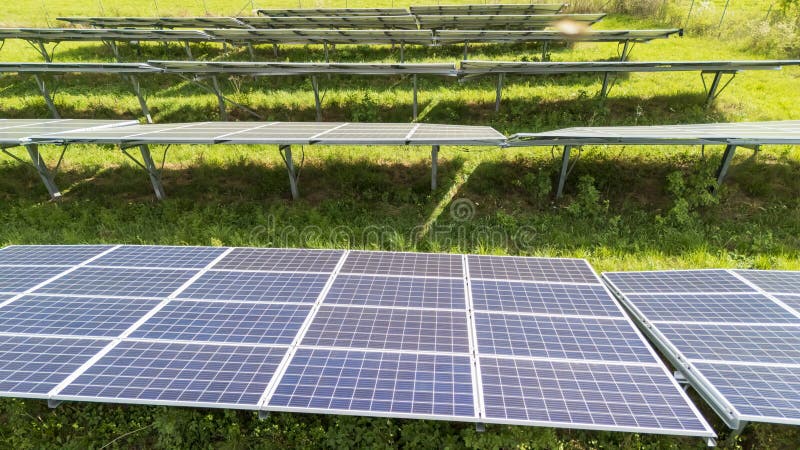 Solar panels installed on rows in a green field, capturing sunlight to generate renewable energy. This contemporary setup reflec. Capturing sunlight stock images, royalty-free photos and pictures