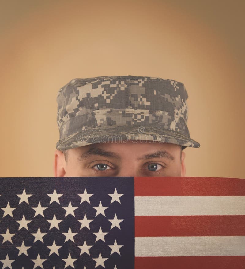 Soldado Holding American Flag a hacer frente foto de archivo libre de regalías Soldado Holding American Flag a hacer frente foto de archivo libre de regalías