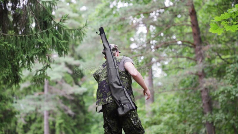 Soldado o cazador joven con el arma en bosque