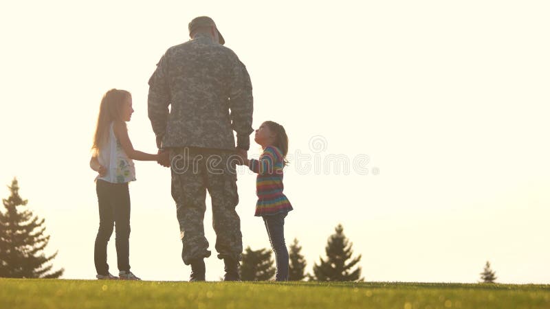 Soldat der hinteren Ansicht im camoubackgrounde mit Kindern