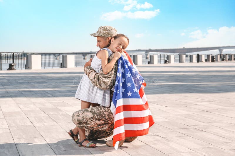 Soldat mit der Fahne von usa und seine kleine Tochter umarmt Raum für Text lizenzfreies stockfoto