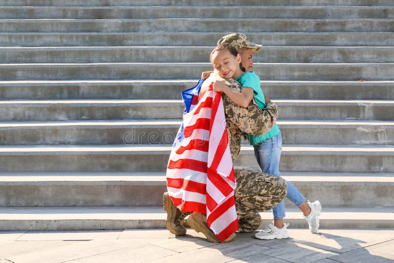 Soldat mit der Fahne von usa und seine kleine Tochter umarmt Raum für Text lizenzfreie stockbilder