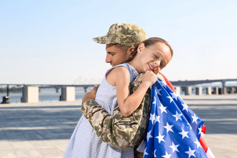 Soldat mit der Fahne von usa und seine kleine Tochter umarmt Raum für Text lizenzfreies stockfoto