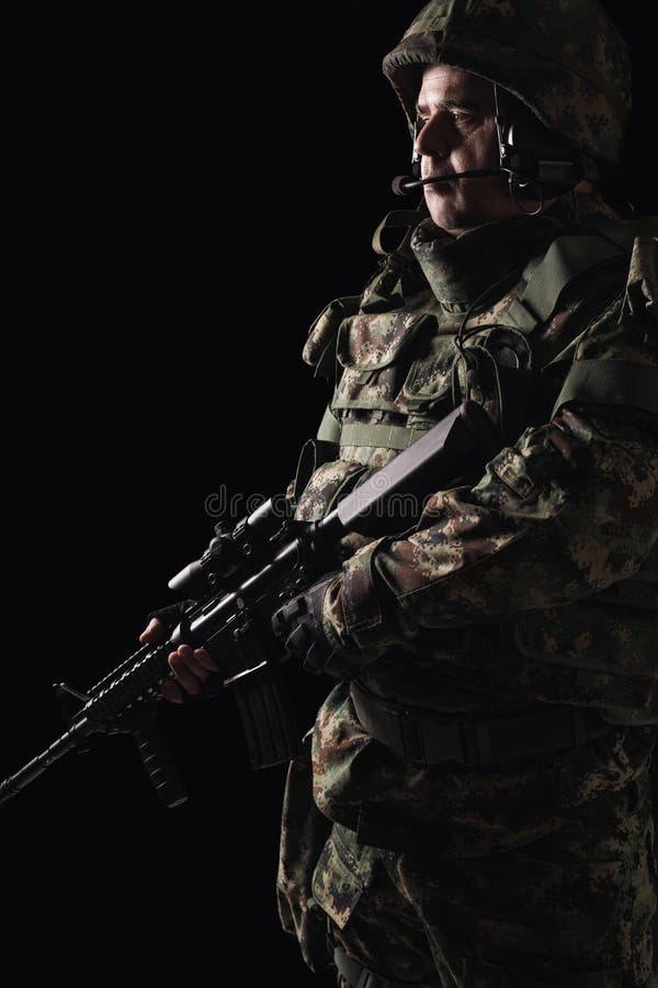 Soldato delle forze speciali con il fucile su fondo scuro fotografia stock libera da diritti Soldato delle forze speciali con il fucile su fondo scuro fotografia stock libera da diritti