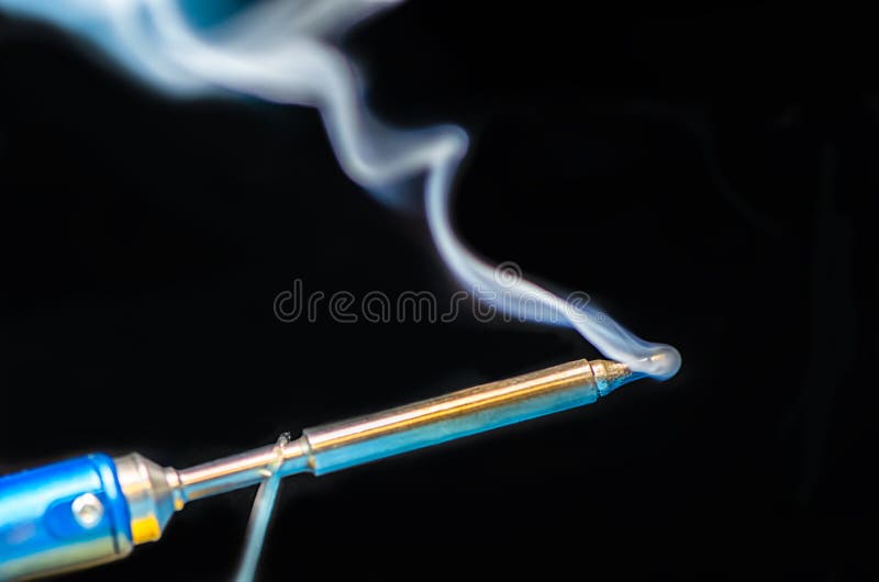 Soldering Iron with Smoke on a Black Background. Electrical Stock Image