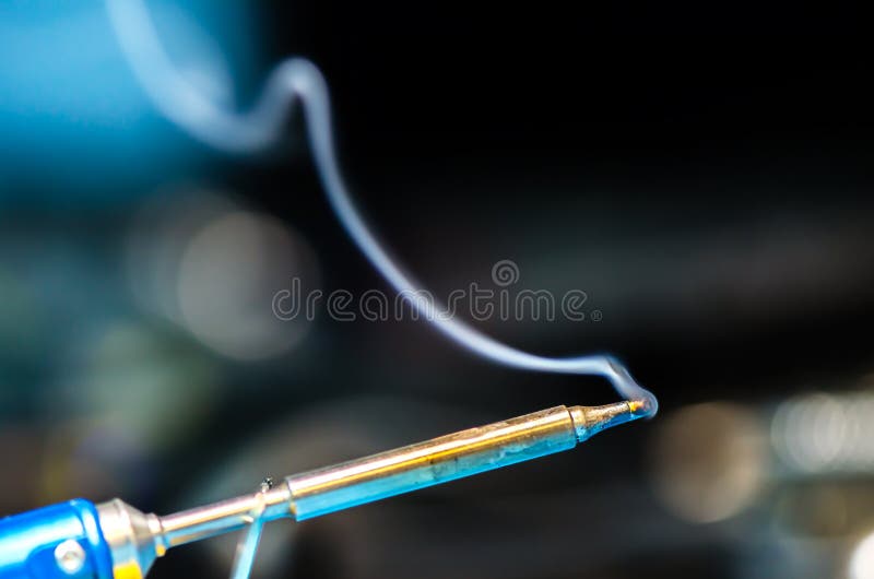 Soldering Iron With Smoke On A Black Background. Electrical Stock Photo