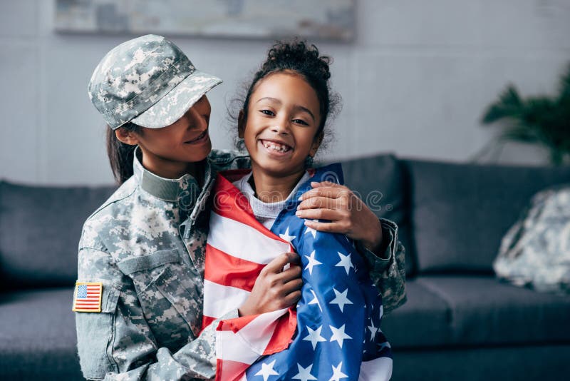 Soldier and daughter wrapped with american flag