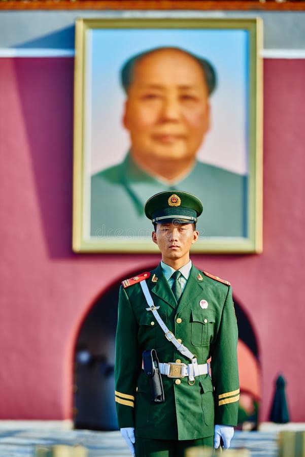 Beijing , China - September 24, 2014: Chinese soldier in front of the soldier in front of mao zedong poster portrait Tiananmen Square forbidden city Beijing China. Beijing , China - September 24, 2014: Chinese soldier in front of the soldier in front of mao zedong poster portrait Tiananmen Square forbidden city Beijing China