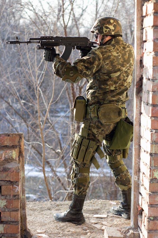 Soldier Standing Near Wall With A Gun Stock Photo Image