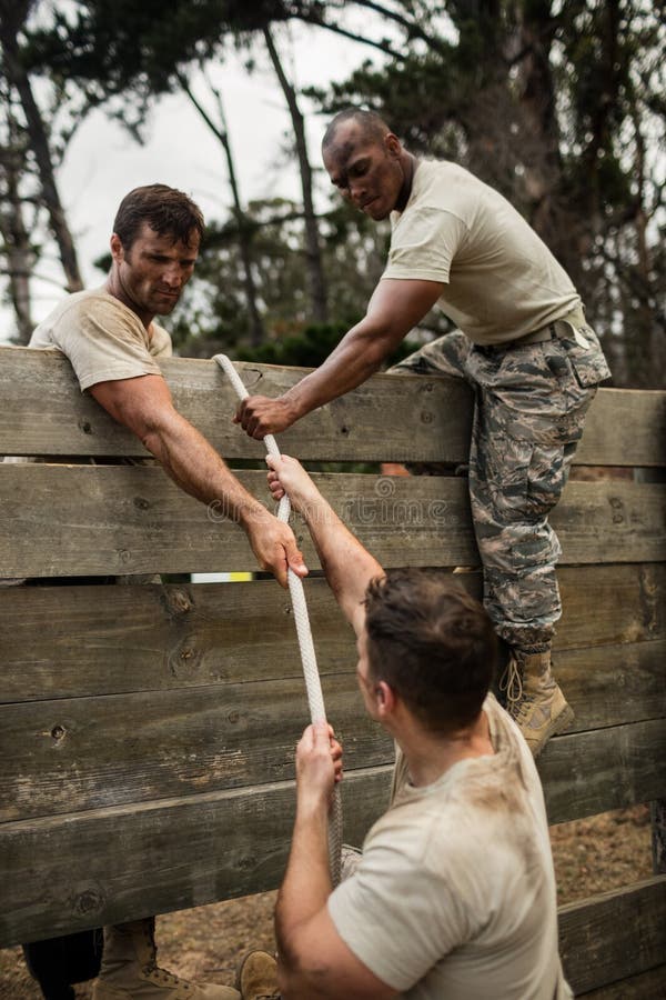 Soldiers Helping Man To Climb Wooden Wall Stock Image Image of climbing, activity 88465835