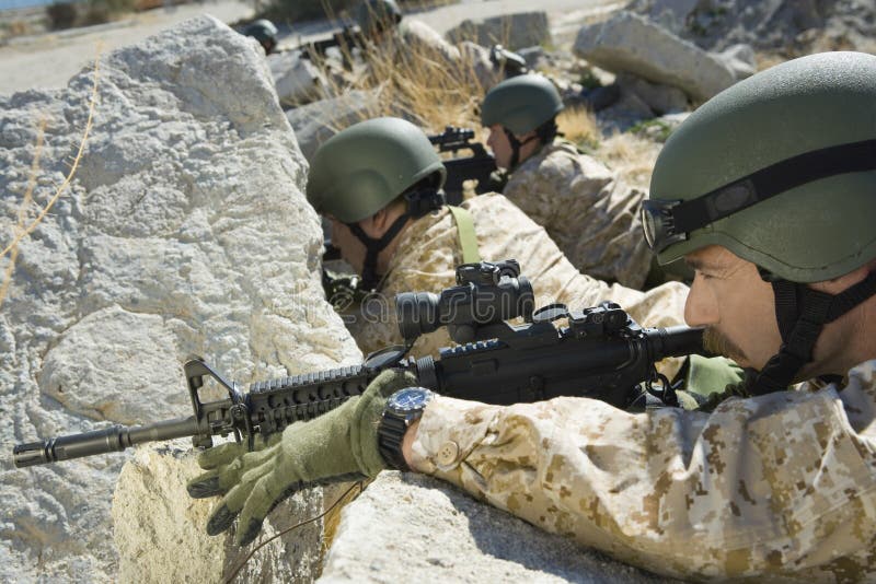 Soldiers With Rifles Hiding Behind Rocks