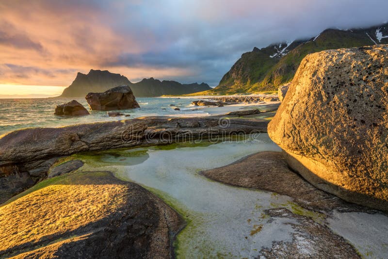 Sole di mezzanotte sopra la spiaggia di Utakleiv sulle isole di Lofoten, Norvegia fotografie stock libere da diritti Sole di mezzanotte sopra la spiaggia di Utakleiv sulle isole di Lofoten, Norvegia fotografie stock libere da diritti