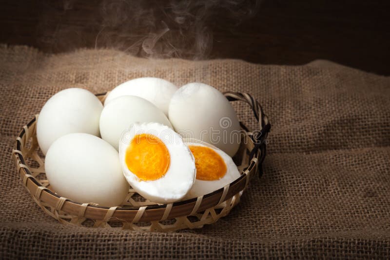 Soleni jajka gotujący się jeść i przygotowywający, stawiają dalej kosz, zamazany tło