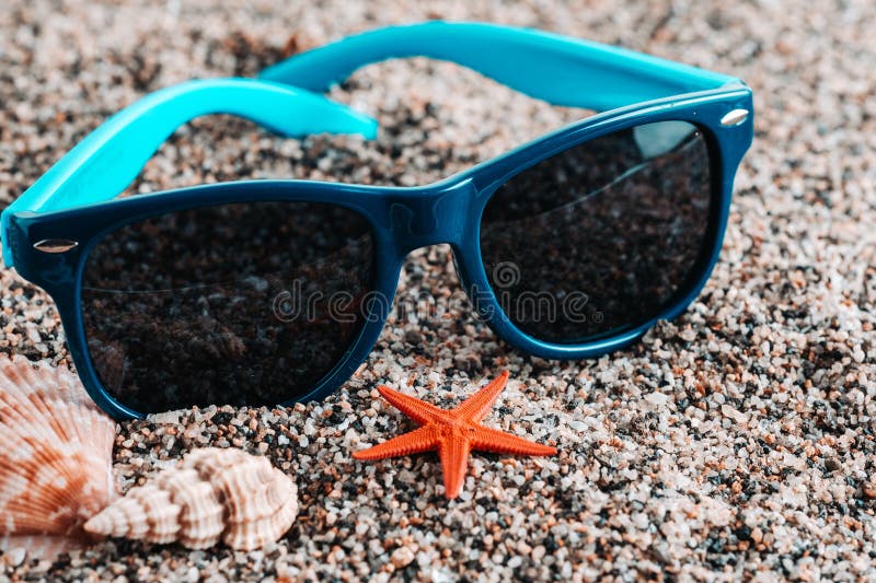 Sunglasses with starfish and seashells on sandy beach. Sunglasses with starfish and seashells on sandy beach