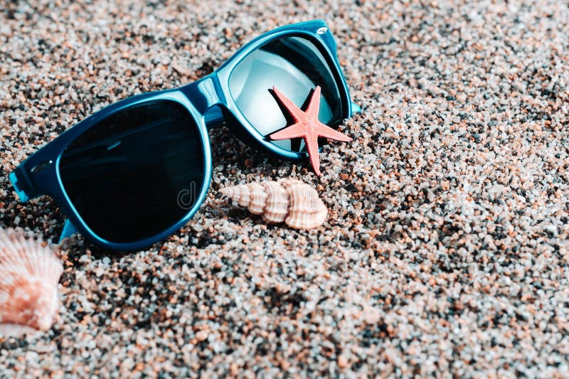 Sunglasses and seashells on the sand. Beach, summer vacation. Sunglasses and seashells on the sand. Beach, summer vacation