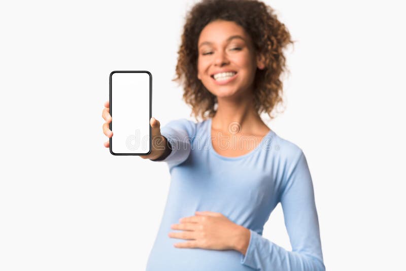 Solicitudes de embarazo Mujer afro mostrando el celular con la pantalla vacía foto de archivo Solicitudes de embarazo Mujer afro mostrando el celular con la pantalla vacía foto de archivo